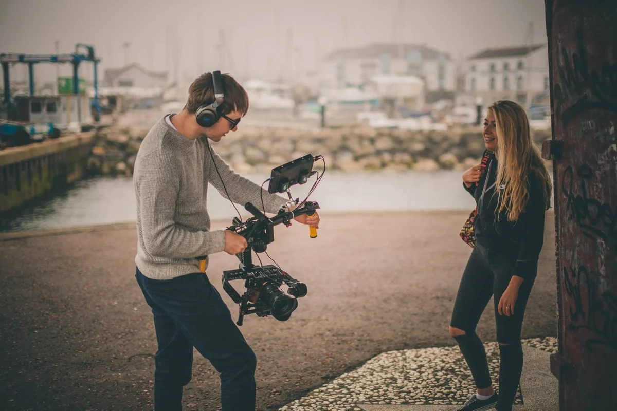 Camera operator filming a campaign scene on the waterfront