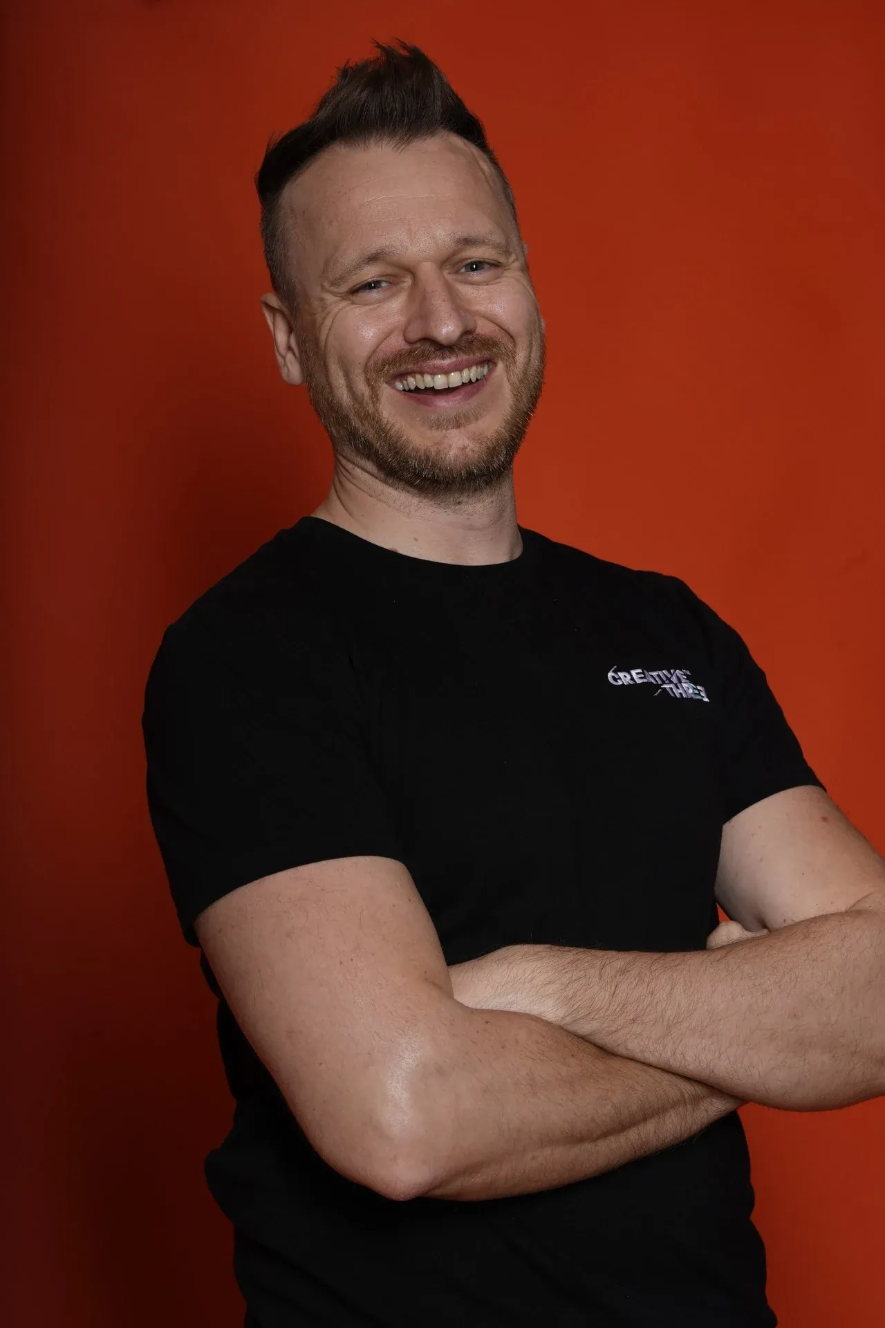 Chris, Creative 3 co-founder, in a black branded T-shirt