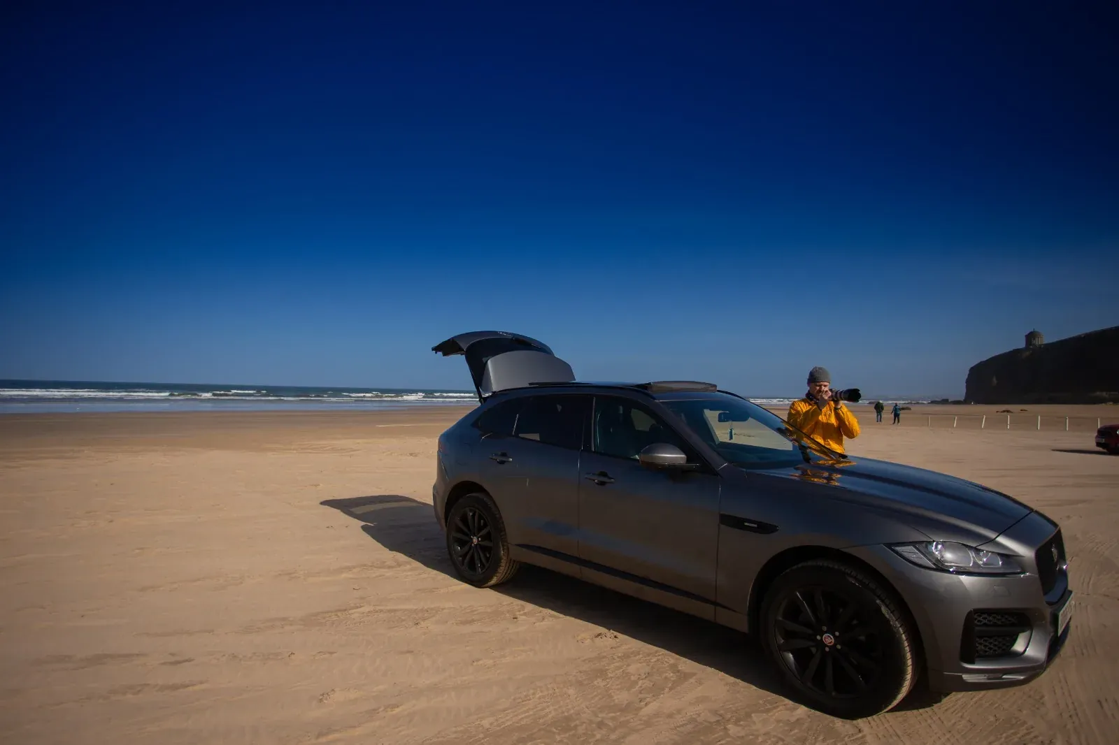 Car photographed on a beach with its door open
