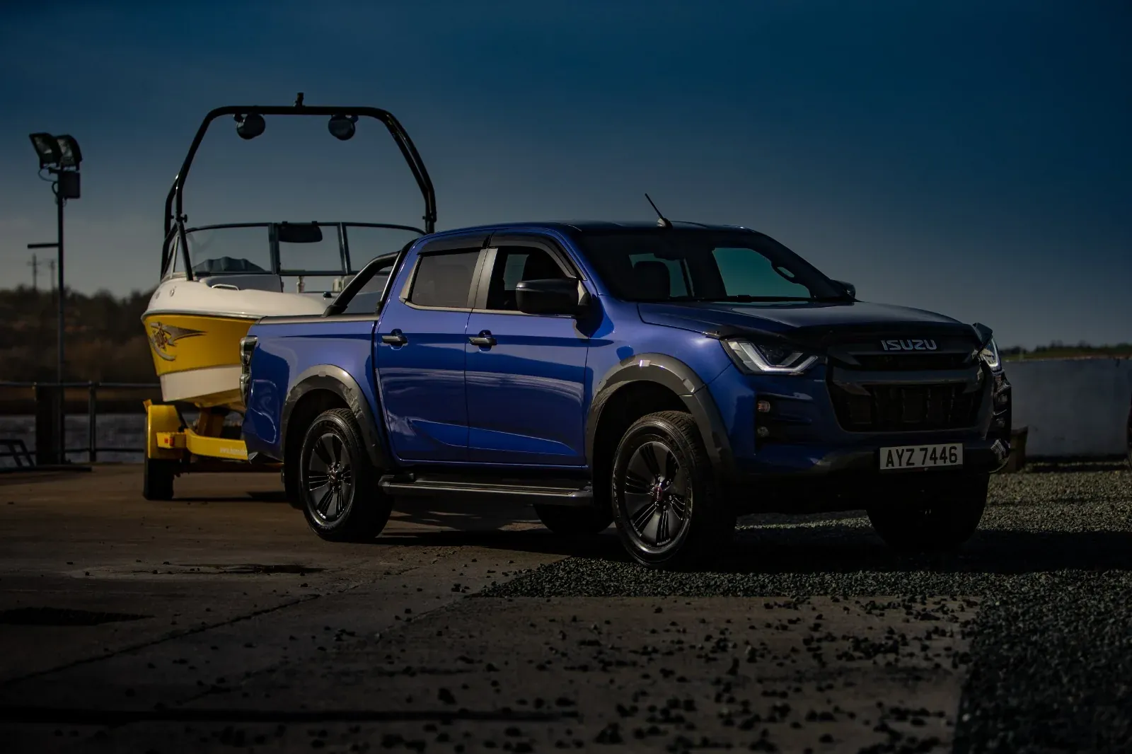 Blue pickup photographed beside the dockside cranes