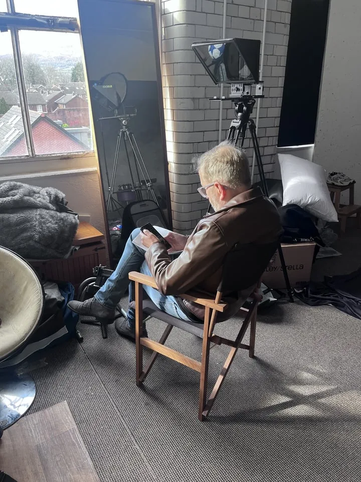 Interview subject seated by a window with production equipment