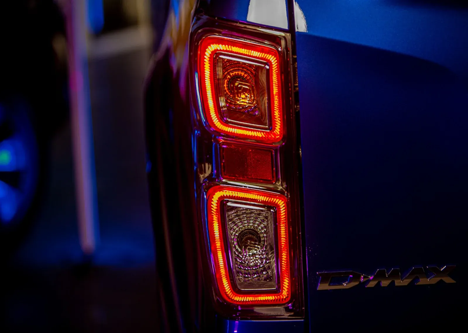 Red tail-light detail against deep blue lighting