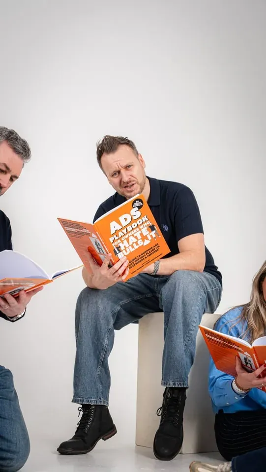 Playful studio portrait with the orange Ads Playbook